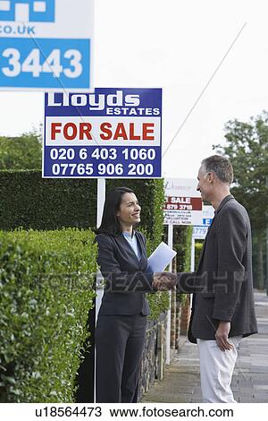 Real estate agent shaking hands with man beside for sale signs View Large Photo Image Stock Image - Real estate agent shaking hands with man beside for sale signs. Fotosearch