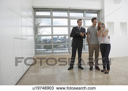 Real estate agent showing couple new apartment View Large Photo Image Stock Image - Real estate agent showing couple new apartment. Fotosearch