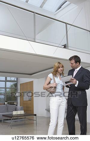 Real estate agent showing woman plan of new home View Large Photo Image Stock Photograph - Real estate agent showing woman plan of new home. Fotosearch