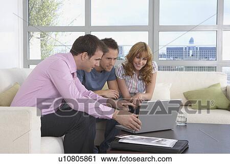 Real estate agent using laptop with couple in new home View Large Photo Image Stock Image - Real estate agent using laptop with couple in new home. Fotosearch