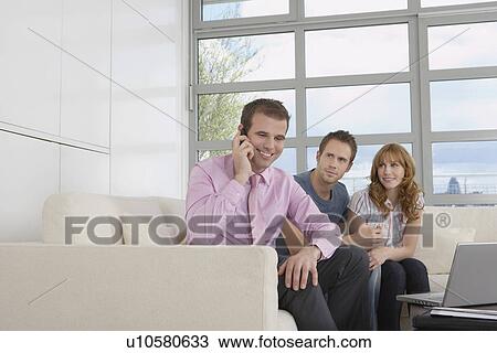 Real estate agent using mobile phone with couple in new home View Large Photo Image Stock Image - Real estate agent using mobile phone with couple in new home. Fotosearch
