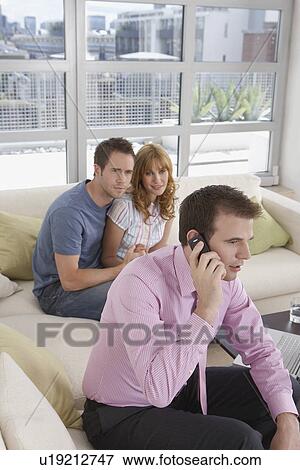 Real estate agent using mobile phone with couple in new home View Large Photo Image Stock Photo - Real estate agent using mobile phone with couple in new home. Fotosearch