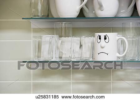 Stock Photography - Sad face mug on kitchen shelf. Fotosearch