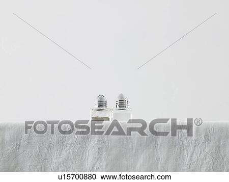 Stock Image - Salt and pepper shakers on table low angle view studio shot. Fotosearch