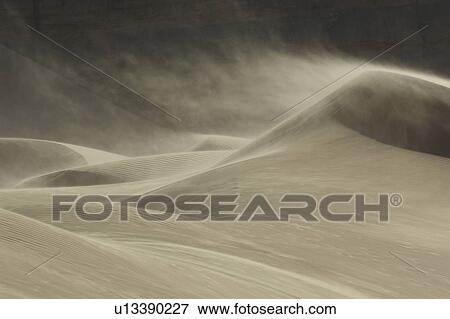 Stock Photo - Sand blowing over sand dune in wind. Fotosearch