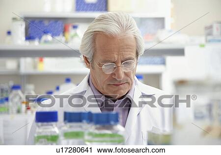 Stock Image - Scientist looking down in laboratory. Fotosearch