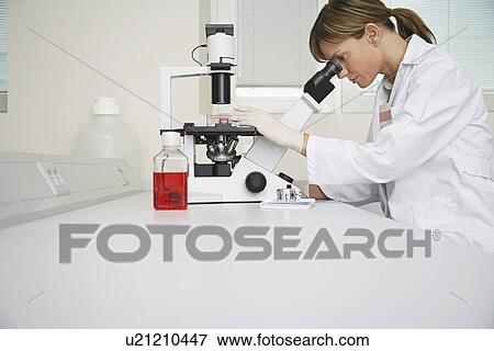 Stock Photo - Scientist using microscope in laboratory. Fotosearch