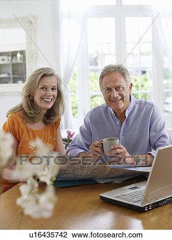Senior couple sitting at dining table portrait View Large Photo Image Stock Image - Senior couple sitting at dining table portrait. Fotosearch