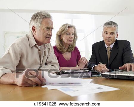 Senior couple sitting at table with financial advisor View Large Photo Image Stock Photo - Senior couple sitting at table with financial advisor. Fotosearch