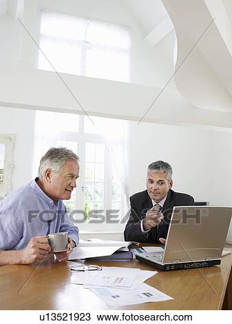 Senior man sitting at table with financial advisor View Large Photo Image Stock Image - Senior man sitting at table with financial advisor. Fotosearch