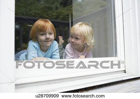Sisters (3-6) indoors lying in front of window portrait View Large Photo Image Stock Photo - Sisters (3-6) indoors lying in front of window portrait. Fotosearch