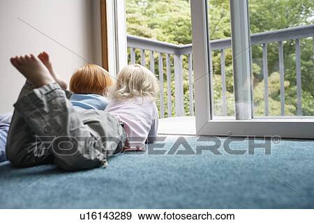 Sisters (3-6) lying on carpet looking through balcony door View Large Photo Image Stock Photo - Sisters (3-6) lying on carpet looking through balcony door. Fotosearch