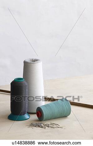 Spools of thead and pins on table View Large Photo Image Stock Photograph - Spools of thead and pins on table. Fotosearch