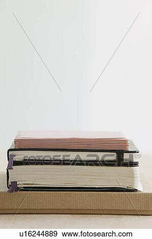 Stack of books and paper stationery studio shot View Large Photo Image Stock Photo - Stack of books and paper stationery studio shot. Fotosearch