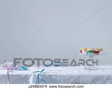 Picture - Streamers and cup cakes on platter on table. Fotosearch