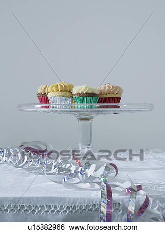 Streamers and cup cakes on table View Large Photo Image Stock Photograph - Streamers and cup cakes on table. Fotosearch