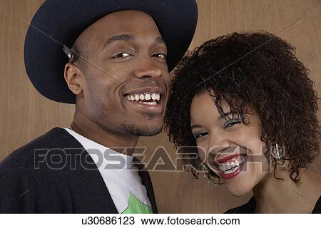 Studio portrait of young couple smiling View Large Photo Image Stock Image - Studio portrait of young couple smiling. Fotosearch