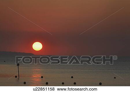 Sun setting over ocean View Large Photo Image Stock Photo - Sun setting over ocean. Fotosearch