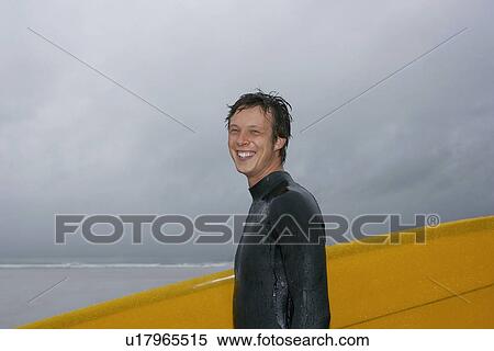 Surfer carrying surfboard on beach portrait side view View Large Photo Image Stock Photography - Surfer carrying surfboard on beach portrait side view. Fotosearch
