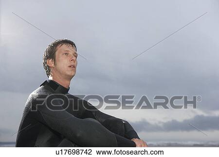 Surfer sitting on beach low angle view View Large Photo Image Stock Image - Surfer sitting on beach low angle view. Fotosearch