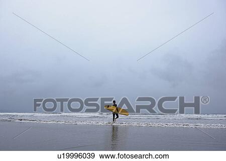 Surfer walking into water back view View Large Photo Image Stock Photo - Surfer walking into water back view. Fotosearch