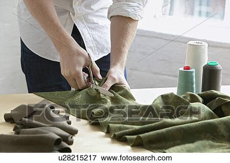 Tailor cutting fabric mid section close up View Large Photo Image Stock Photo - Tailor cutting fabric mid section close up. Fotosearch