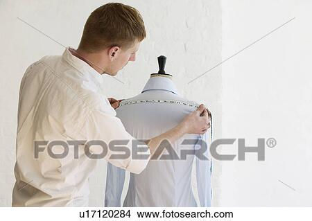 Tailor measuring blouse hanging on mannequin back view View Large Photo Image Picture - Tailor measuring blouse hanging on mannequin back view. Fotosearch