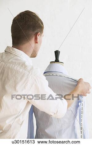 Tailor measuring blouse hanging on mannequin back view View Large Photo Image Stock Image - Tailor measuring blouse hanging on mannequin back view. Fotosearch