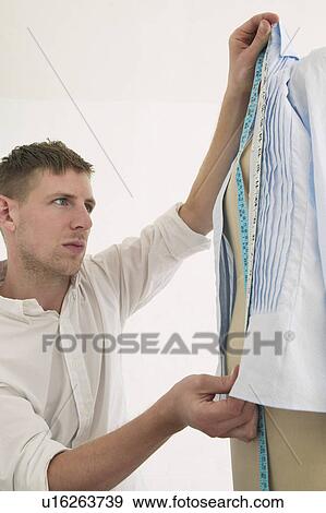 Tailor measuring blouse hanging on mannequin View Large Photo Image Stock Photo - Tailor measuring blouse hanging on mannequin. Fotosearch