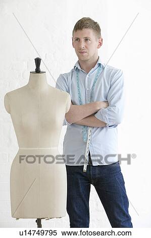 Tailor standing next to mannequin portrait View Large Photo Image Stock Photography - Tailor standing next to mannequin portrait. Fotosearch