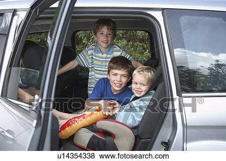 Stock Photo - Three boys (3-11) in car portrait. Fotosearch