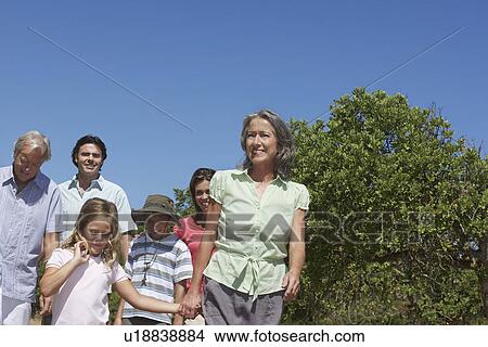 Three-generation family with two children (6-11) walking outdoors View Large Photo Image Picture - Three-generation family with two children (6-11) walking outdoors. Fotosearch
