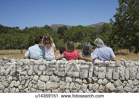 Three-generation family with two children (6-11) by stone wall back view View Large Photo Image Stock Image - Three-generation family with two children (6-11) by stone wall back view. Fotosearch