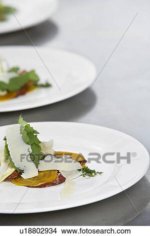 Picture - Three plates of salad with grated cheese. Fotosearch