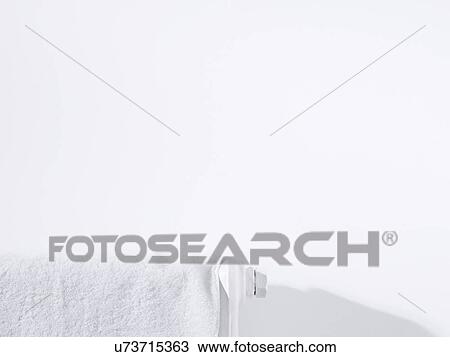 Stock Image - Towel on radiator and white wall. Fotosearch
