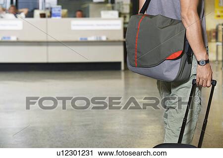 Stock Image - Traveller with bags at airport. Fotosearch