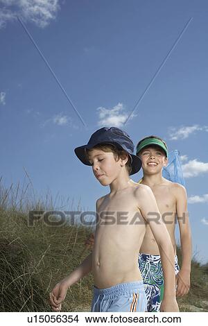 Two boys (6-11) walking in sand dunes View Large Photo Image Picture - Two boys (6-11) walking in sand dunes. Fotosearch