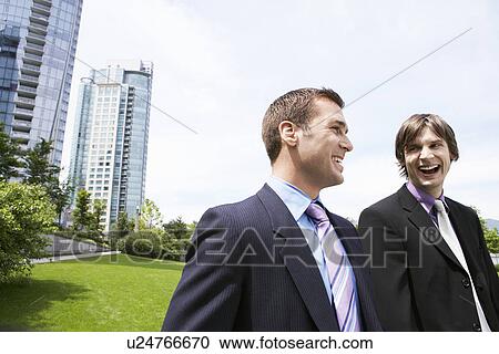 Stock Image - Two business men laughing near office buildings. Fotosearch