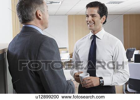 Two business men talking in office View Large Photo Image Stock Image - Two business men talking in office. Fotosearch