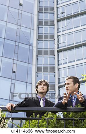 Stock Photograph - Two business men talking outside office. Fotosearch