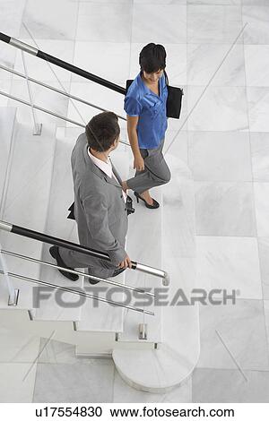 Two business people walking down stairs View Large Photo Image Stock Image - Two business people walking down stairs. Fotosearch
