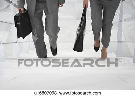 Stock Photo - Two business people walking up stairs. Fotosearch