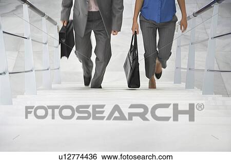 Two business people walking up stairs View Large Photo Image Stock Photograph - Two business people walking up stairs. Fotosearch