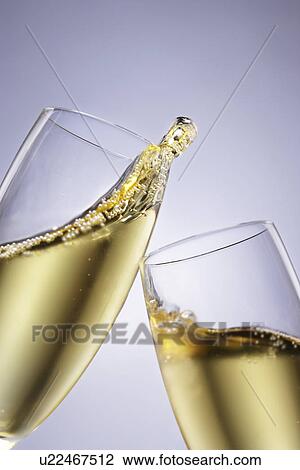 Stock Image - Two champagne glasses toasting close-up. Fotosearch