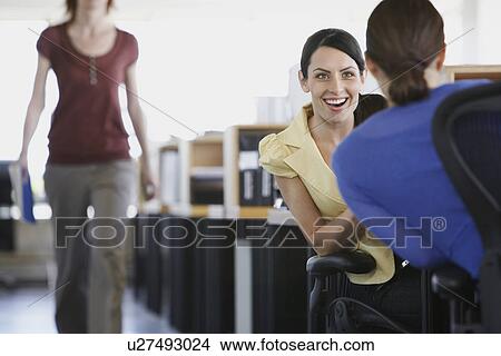 Two female business colleagues talking in office View Large Photo Image Picture - Two female business colleagues talking in office. Fotosearch