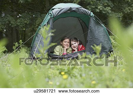 Stock Image - Two girls (7-9) in tent portrait. Fotosearch