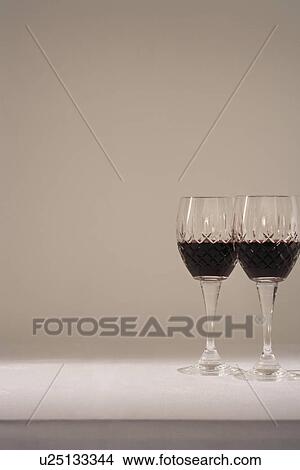 Two glasses of red wine on table View Large Photo Image Picture - Two glasses of red wine on table. Fotosearch