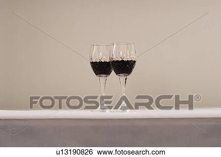 Two glasses of red wine on table View Large Photo Image Stock Photograph - Two glasses of red wine on table. Fotosearch