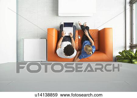 Two people using laptop in reception room view from above View Large Photo Image Stock Photo - Two people using laptop in reception room view from above. Fotosearch