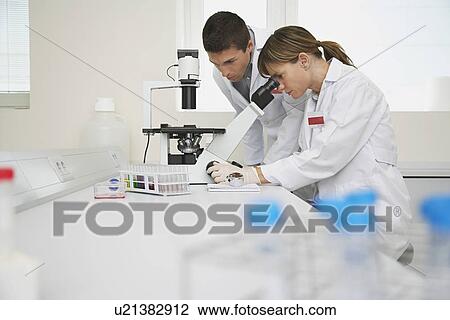 Two scientists using microscope in laboratory View Large Photo Image Stock Image - Two scientists using microscope in laboratory. Fotosearch